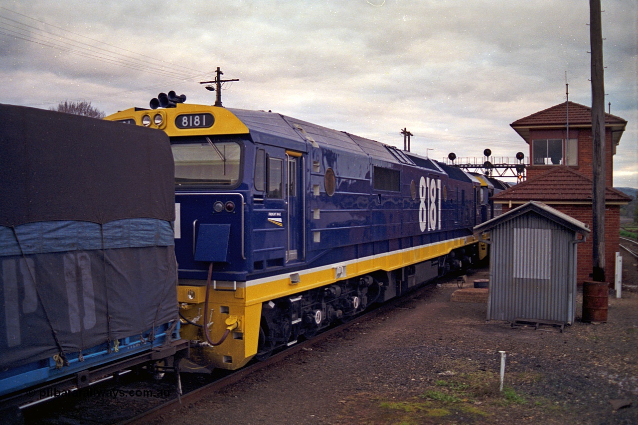 166-09
Albury South Signal Box, brand new NSWSRA 81 class locomotive 8181 Clyde Engineering EMD model JT26C-2SS serial 91-1278 in Freight Rail Stealth livery arrives as second unit on a Melbourne bound goods train, the two 81 class units will be swapped out for V/Line motive power, the broad gauge platform track can been seen on the far right behind the signal box.
Keywords: 81-class;8181;Clyde-Engineering-Kelso-NSW;EMD;JT26C-2SS;91-1278;