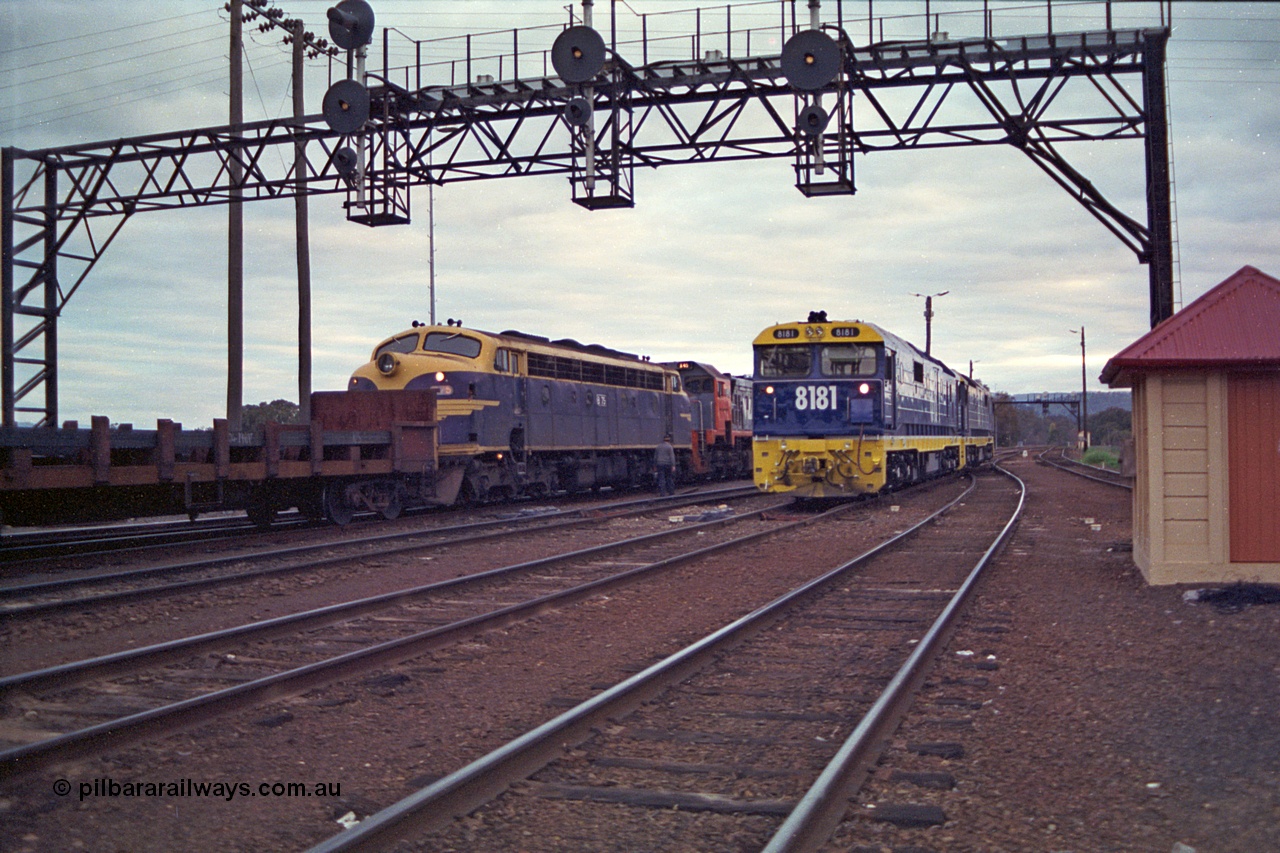 166-10
Albury, South Yard area, brand new NSWSRA 81 class locomotive 8181 Clyde Engineering EMD model JT26C-2SS serial 91-1278 in Freight Rail Stealth livery shunts back to loco with a sister unit passing aging V/Line broad gauge B class loco B 75 Clyde Engineering EMD model ML2 serial ML2-16 still in original Victorian Railways blue and yellow livery as third unit on the up Long Island slab steel train 9334 as it awaits departure time
Keywords: 81-class;8181;Clyde-Engineering-Kelso-NSW;EMD;JT26C-2SS;91-1278;