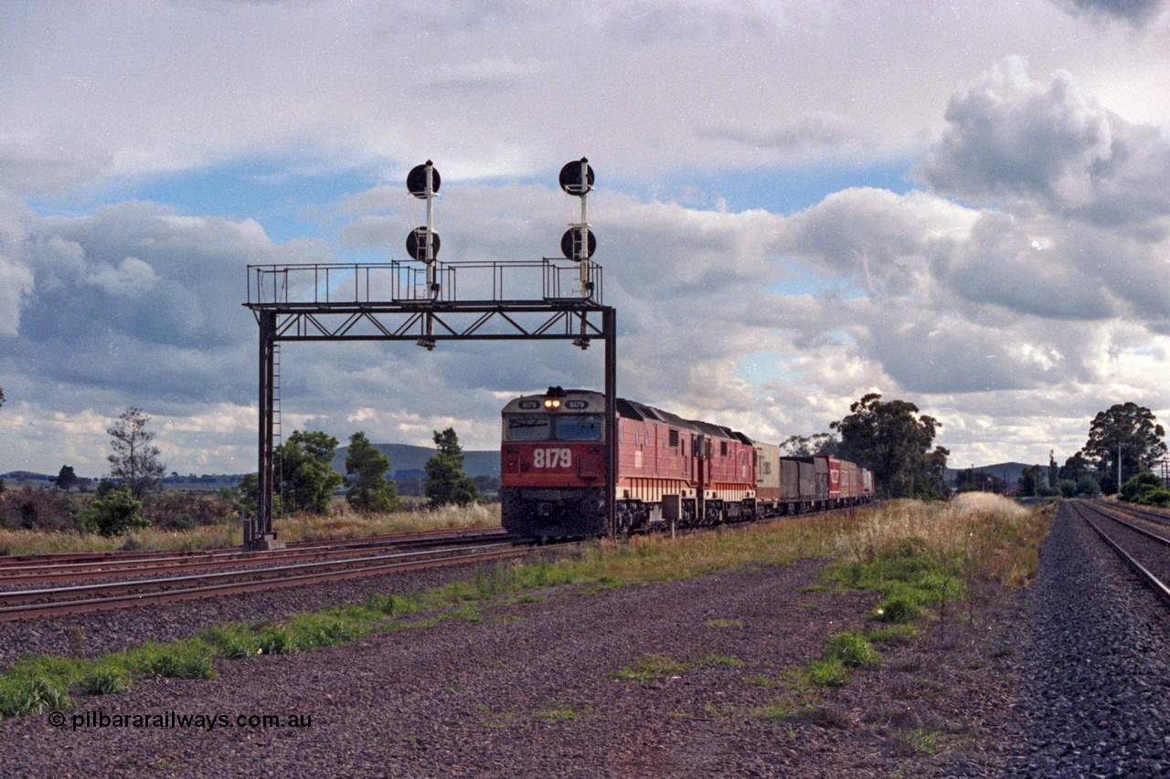 167-00
Wallan Loop north end NSWSRA standard gauge candy liveried 81 class locos 8179 Clyde Engineering EMD model JT26C-2SS serial 85-1098 and sister power an Albury bound goods service, broad gauge lines on the right.
Keywords: 81-class;8179;Clyde-Engineering-Kelso-NSW;EMD;JT26C-2SS;85-1098;