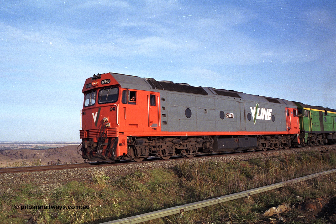 168-04
Bank Box Loop, down V/Line broad gauge goods train to Adelaide behind G class G 540 Clyde Engineering EMD model JT26C-2SS serial 89-1273 and Australian National 700 class 704 AE Goodwin ALCo model DL500G serial G6059-2 take the mainline to cross an up passenger train.
Keywords: G-class;G540;Clyde-Engineering-Somerton-Victoria;EMD;JT26C-2SS;89-1273;