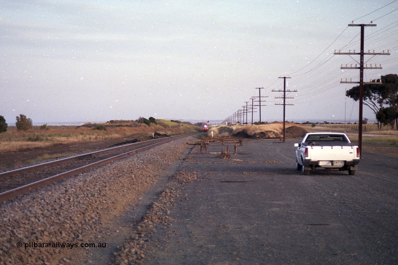 168-11
Bank Box Loop, climbing the grade in the distance looking towards Bacchus Marsh are a pair of V/Line G class units with an Adelaide bound freighter.
