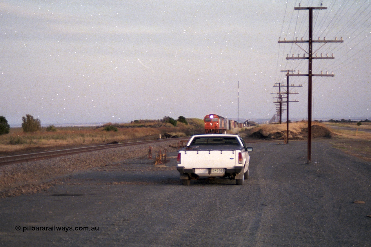 168-12
Bank Box Loop, climbing the grade in the distance looking towards Bacchus Marsh are a pair of V/Line G class units with an Adelaide bound freighter.
