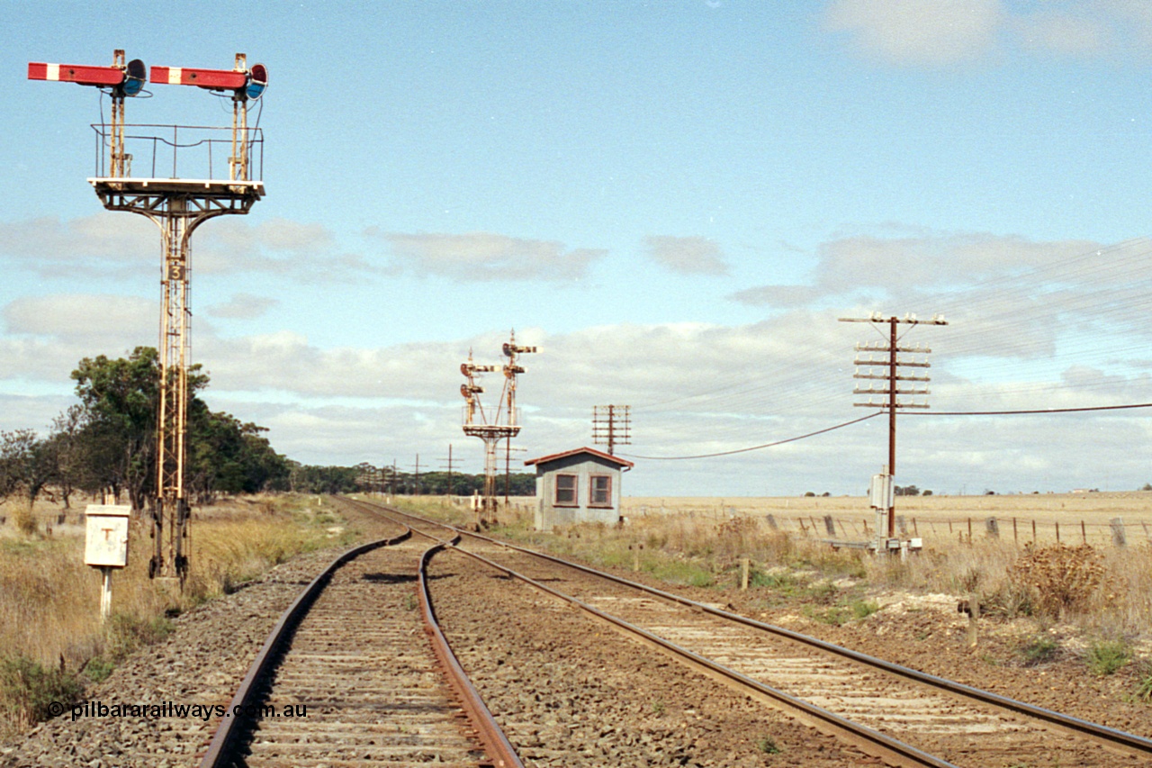 171-11
Trawalla station yard overview, looking towards Melbourne down the end of No.2 Road, semaphore Signal Post 3 left arm Home for No. 2A Road to Main Line and right arm Home for No.1 Road to Main Line, telephone cabinet facing camera, semaphore signal Post 2 facing down trains, with electric interlocking room for motorised point machine.
