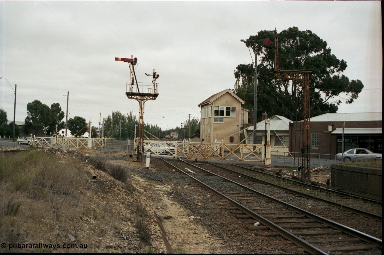 172-20
Ballarat East signal box, track view looking west across Humffray Street interlocked gates, semaphore signal post 5 and disc signal post 5A frame the gates, the former passenger platform is visible on the right.
