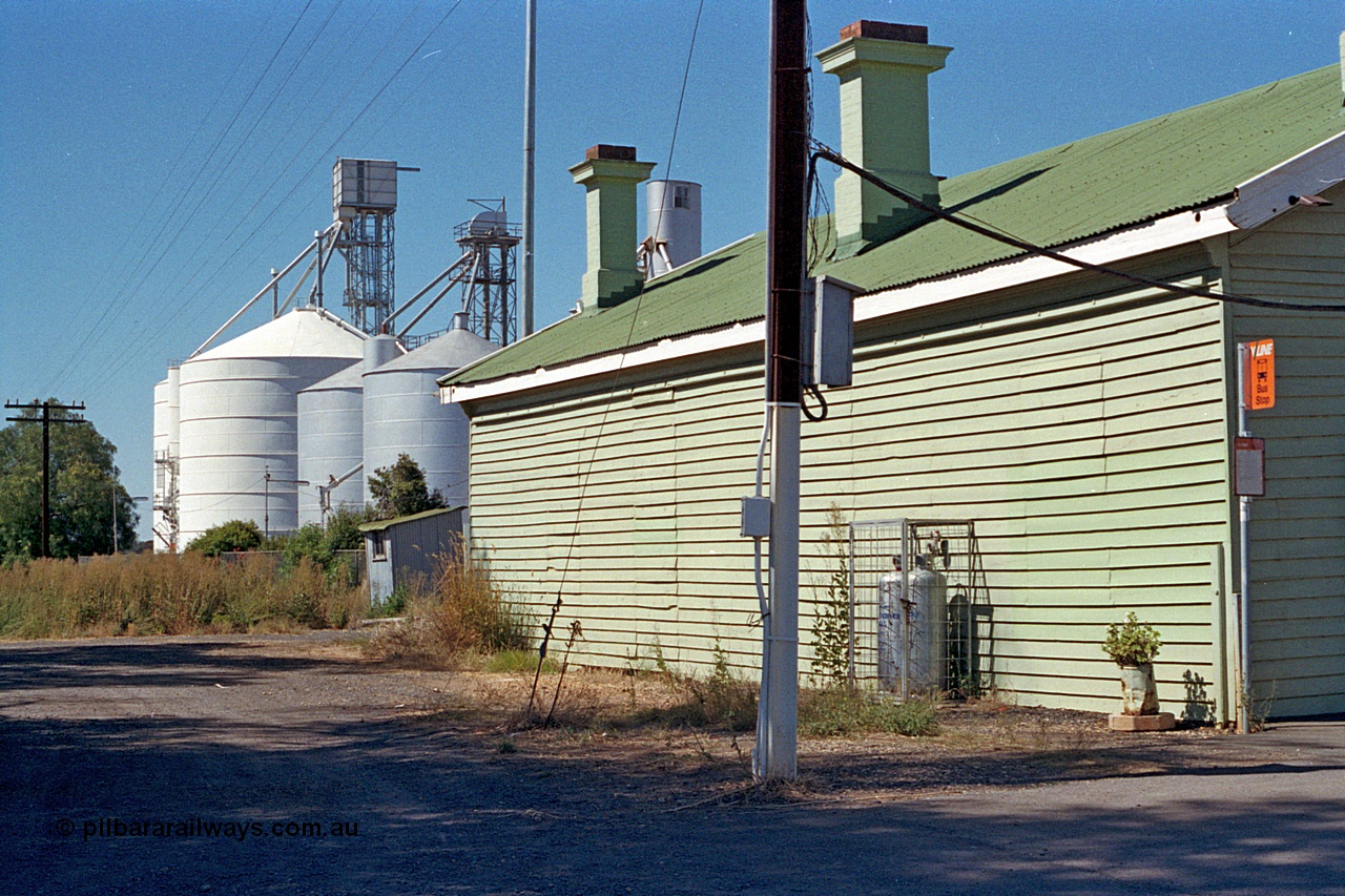 173-23
Murchison East, rear view of station building looking north, shows bus stop sign, gas cylinders and both Ascom and Ascom Jumbo style silos complexes.
