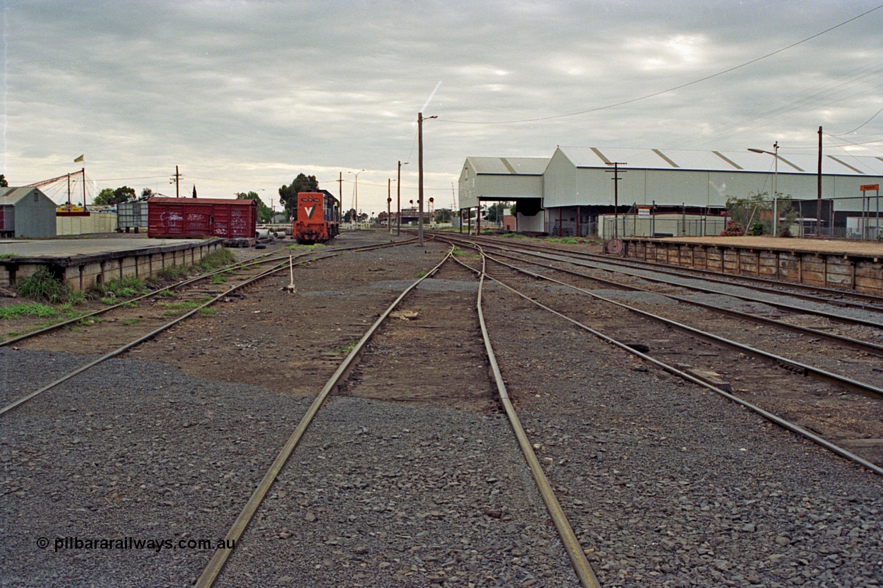 175-07
Shepparton station yard overview looking north from No.4 Road, goods loading platform, grounded B van (was B 325), No.5 Rd and stabled V/Line broad gauge T classes on the left, Tubemakers awning and warehouse with station platform on the right.
Keywords: B-type;B325;fixed-wheel-waggon;