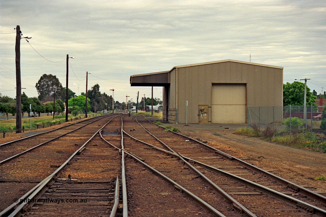 175-11
Shepparton yard overview looking south from the end of the yard, disused loading shed with canopy, up and down home semaphore signal post in the distance, roads are from left, No.1, No.2 or mainline, and an extension of No.3 Rd.
