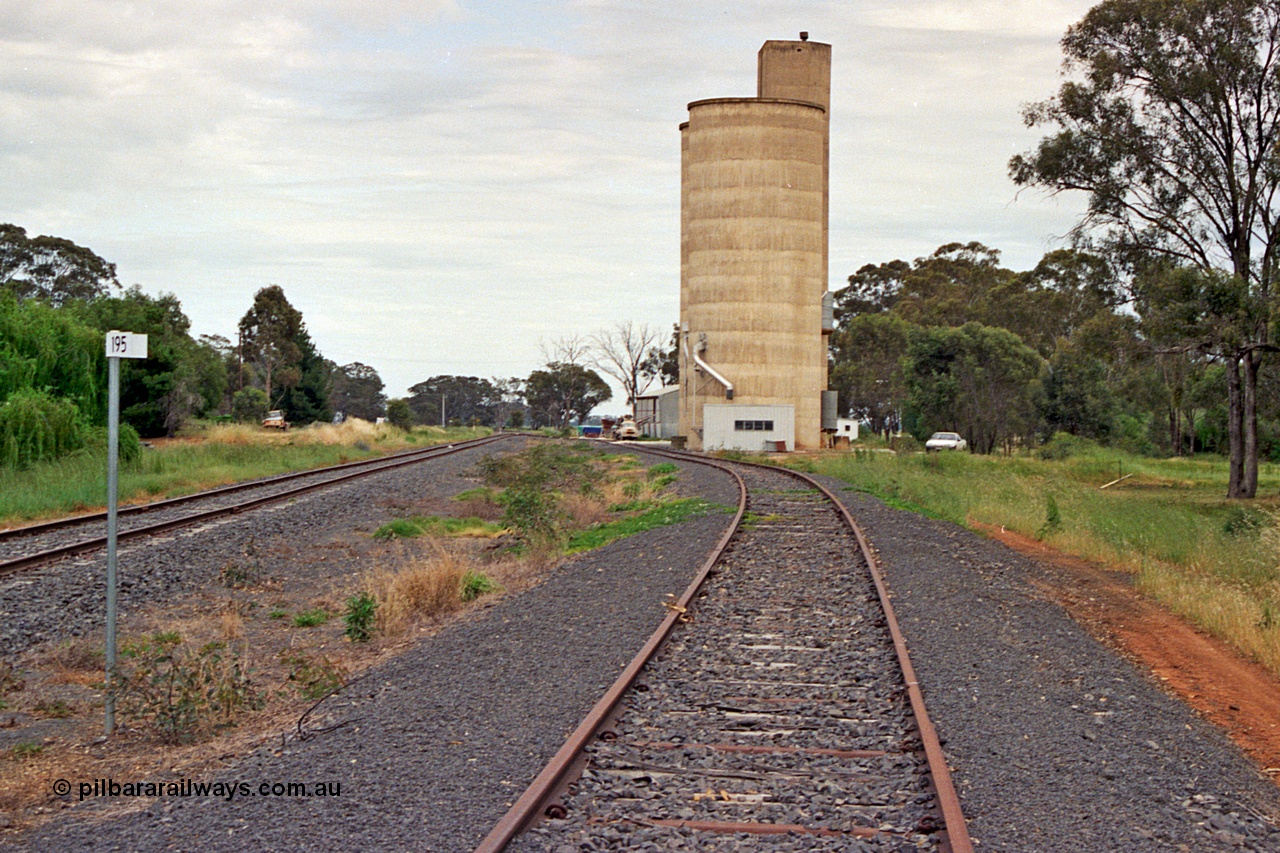 175-20
Pine Lodge, yard overview looking towards Shepparton from the 195 km post, mainline on the left, site of former station and platform on the left, Williamstown style silo complex with super phosphate shed beyond it on the right.
