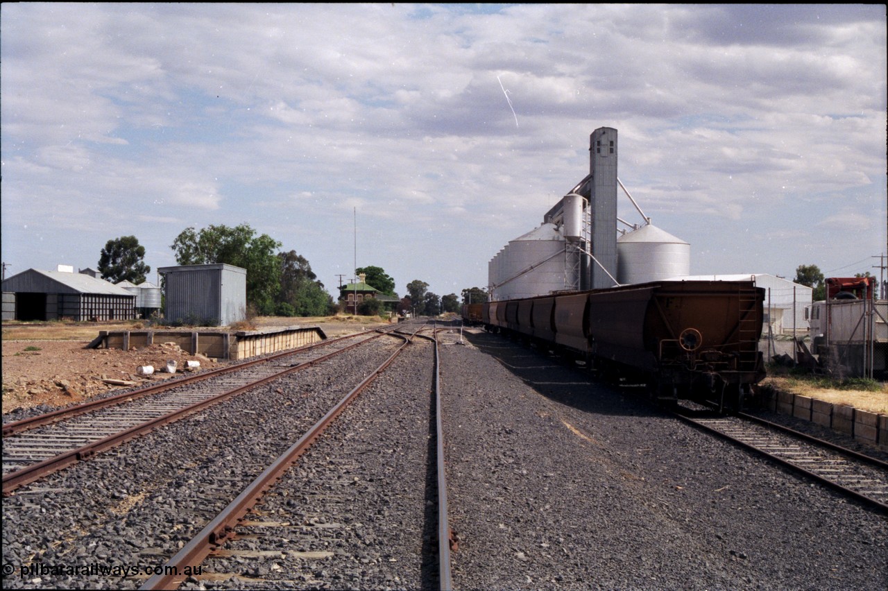 176-04
Yarrawonga station yard overview, looking south, Grain Elevators Board H style horizontal storage bunker at left, goods shed and platform, station building in the distance, V/Line Grain broad gauge VHGF type bogie grain waggons, Grain Elevators Board Ascom style sub-terminal silo complex, with gravitational loading road at right.
Keywords: VHGF-type;
