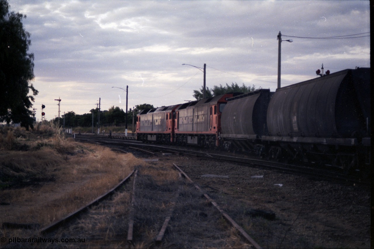 176-23
Wodonga, a pair of V/Line standard gauge G class units, lead by G 520 Clyde Engineering EMD model JT26C-2SS serial 85-1233 power an up goods train bound for Melbourne, the rails in the foreground are the former broad gauge Cattle Sidings 4 and 5 and the Amoco Siding, the standard gauge Cattle Siding track is visible running to the left off the mainline, the semaphore signals are for the broad gauge yard and the colour search light signal post for the standard gauge Wodonga Loop.
