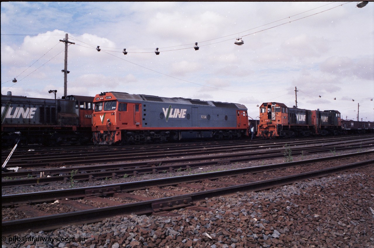 177-04
Tottenham Yard, view from the middle of the yard of broad gauge Clyde Engineering EMD model G6B V/Line shunt locomotives of the Y class, Y 130 serial 65-396 with a green louvre van and Y 118 serial 63-308 and Y 171 serial 68-591 as they go about Saturday morning shunting duties. In the final years of V/Line operation, the Y class were operated in pairs to shunt Tottenham Yard.
Keywords: G-class;G536;Clyde-Engineering-Somerton-Victoria;EMD;JT26C-2SS;88-1266;