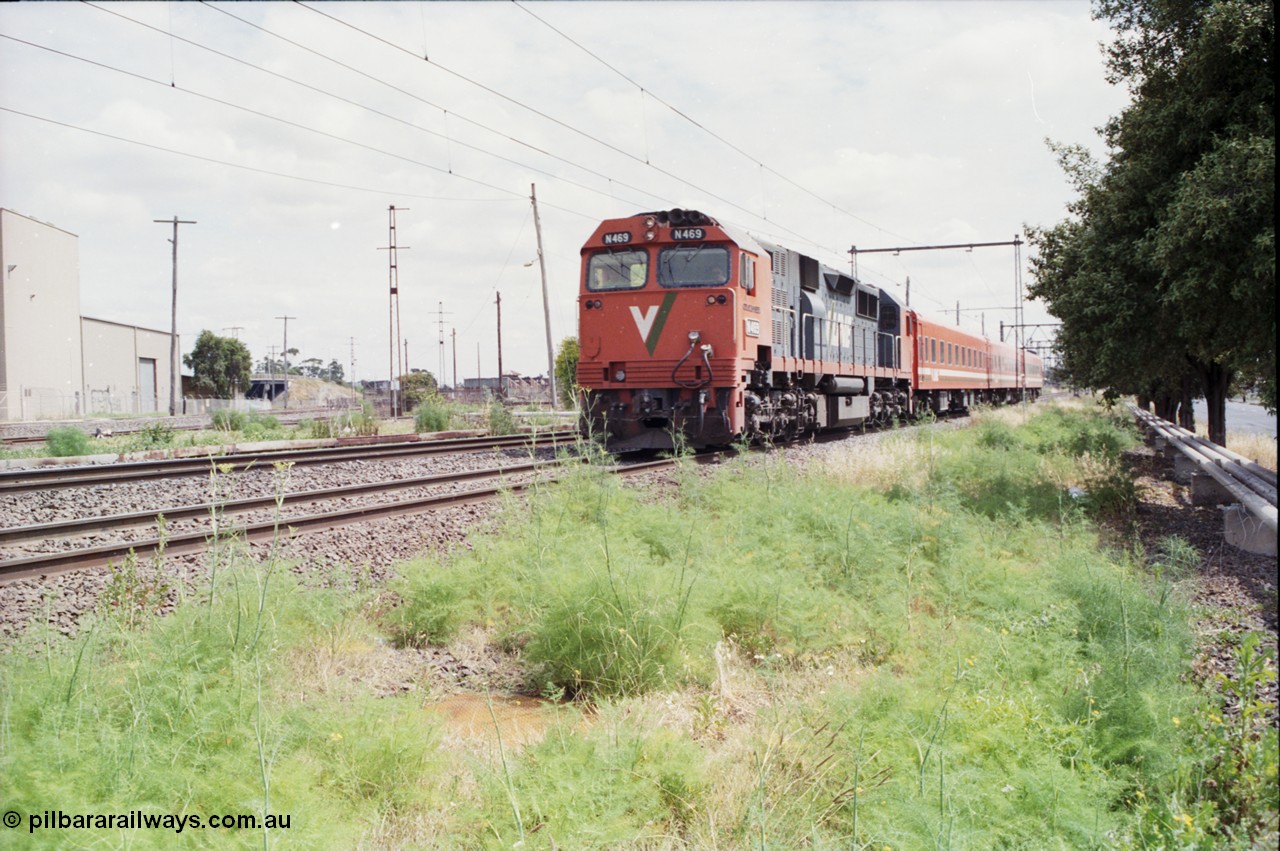 177-06
Newport Junction, V/Line broad gauge N class locomotive N 469 'City of Morwell' Clyde Engineering EMD model JT22HC-2 serial 86-1198 leads a down Geelong passenger train with an N set consist, the Newport - Sunshine Loop Line is running under the road overpass in the background, Spotswood Reclamation Yards are also just visible.
Keywords: N-class;N469;Clyde-Engineering-Somerton-Victoria;EMD;JT22HC-2;86-1198;