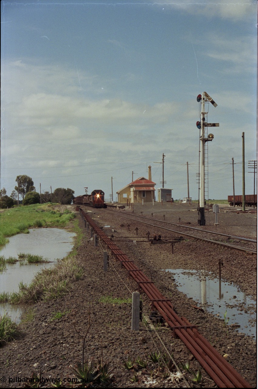 179-04
Gheringhap, yard overview looking east, broad gauge V/Line down goods train 9153 departs for Maroona with the signal on post 4 pulled off for the Maroona line, point rodding and interlocking is spaced away from the line as this location used to have double mainlines, on the right are gypsum waggons in Sidings B.
Keywords: X-class;X53;Clyde-Engineering-Rosewater-SA;EMD;G26C;75-800;