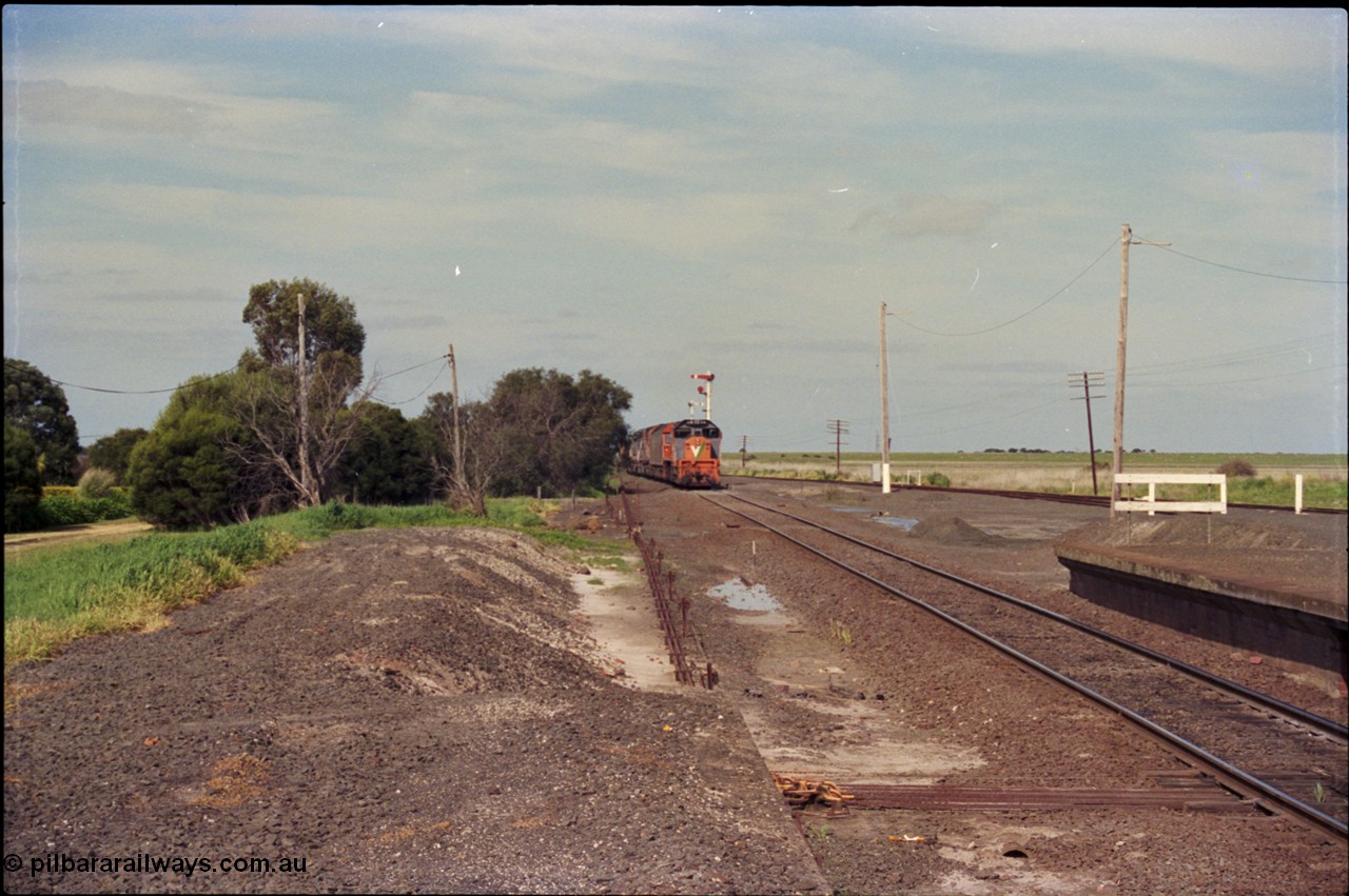 179-11
Gheringhap, yard view looking east towards Geelong, V/Line broad gauge goods train 9169 is approaching the station, taken from form up platform, point rodding can be seen leaving the signal box.
