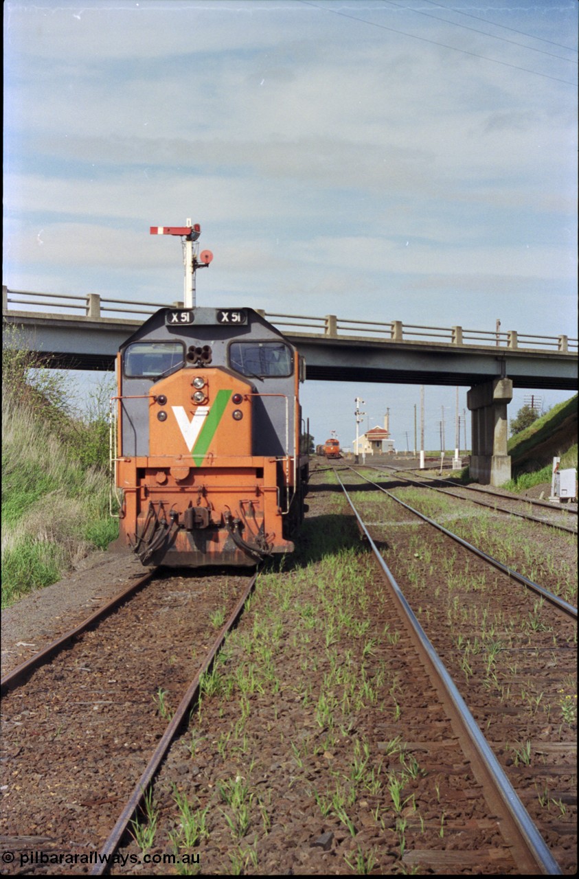 179-21
Gheringhap, station yard overview looking east from the Ballarat line and Siding C, the line to Maroona is on the right, in the back ground semaphore signal post 4 is pulled of for down goods train 9169 to depart, V/Line broad gauge X class locomotive X 51 Clyde Engineering EMD model G26C serial 75-798 is awaiting light engines from Geelong to come and retrieve it.
Keywords: X-class;X51;Clyde-Engineering-Rosewater-SA;EMD;G26C;75-798;