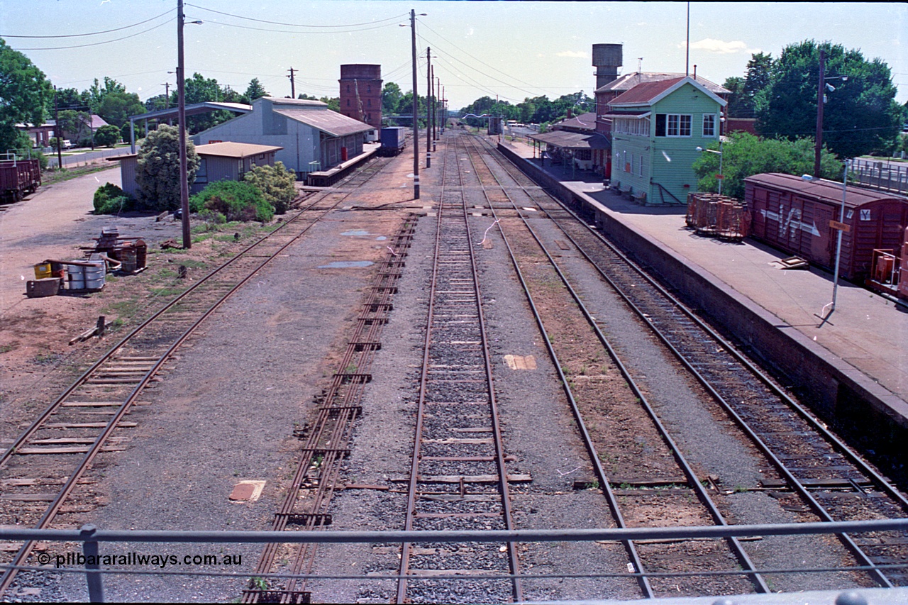 180-15
Wangaratta, rationalised yard view looking north from the southern end footbridge, show the removed No.4 Road, with goods shed, water tower and Freight Gate canopy on the left, and station building and platform with signal box and VLBY type bogie louvre parcels van on the right, point rodding is running along No.3 Road.
Keywords: VLBY-type;