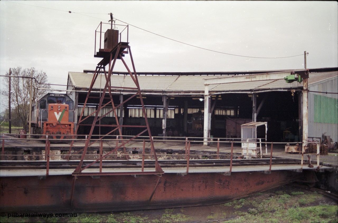 181-19
Traralgon loco depot roundhouse and turntable overview, X class X 42 Clyde Engineering EMD model G26C serial 70-705, turntable and pit, 5 stall round house with RT class rail tractor and a bogie open waggon, gantry crane at right.
Keywords: X-class;X42;Clyde-Engineering-Granville-NSW;EMD;G26C;70-705;