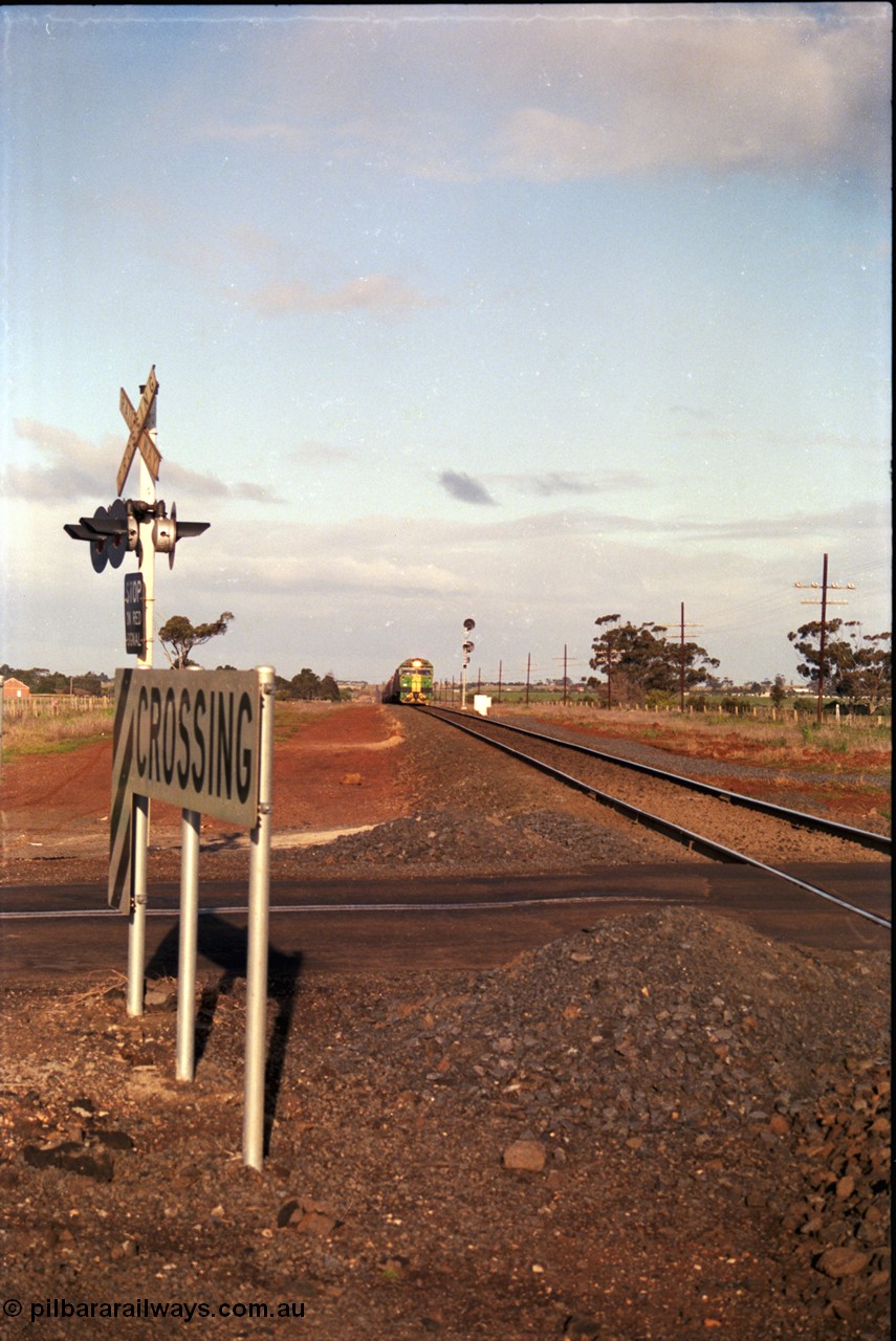 183-04
Rockbank, an Adelaide bound down broad gauge goods train behind Australian National BL class BL 31 Clyde Engineering EMD model JT26C-2SS serial 83-1015 and 700 class 705 AE Goodwin ALCo model DL500G serial G6059-3 climbs the grade as it approaches the grade crossing for Station Road.

