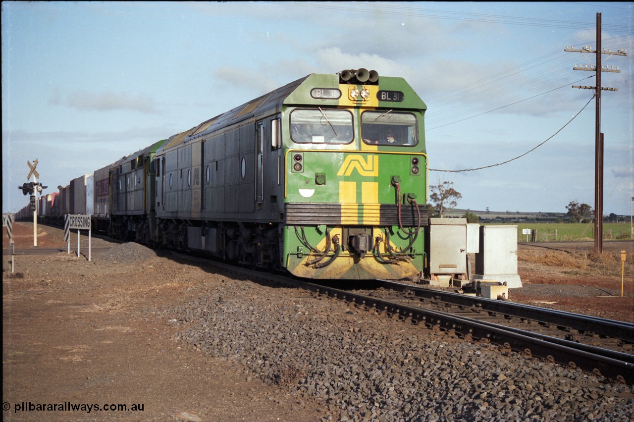 183-06
Rockbank, an Adelaide bound down broad gauge goods train behind Australian National BL class BL 31 Clyde Engineering EMD model JT26C-2SS serial 83-1015 and 700 class 705 AE Goodwin ALCo model DL500G serial G6059-3 at the grade crossing for Station Road.
Keywords: BL-class;BL31;Clyde-Engineering-Rosewater-SA;EMD;JT26C-2SS;83-1015;