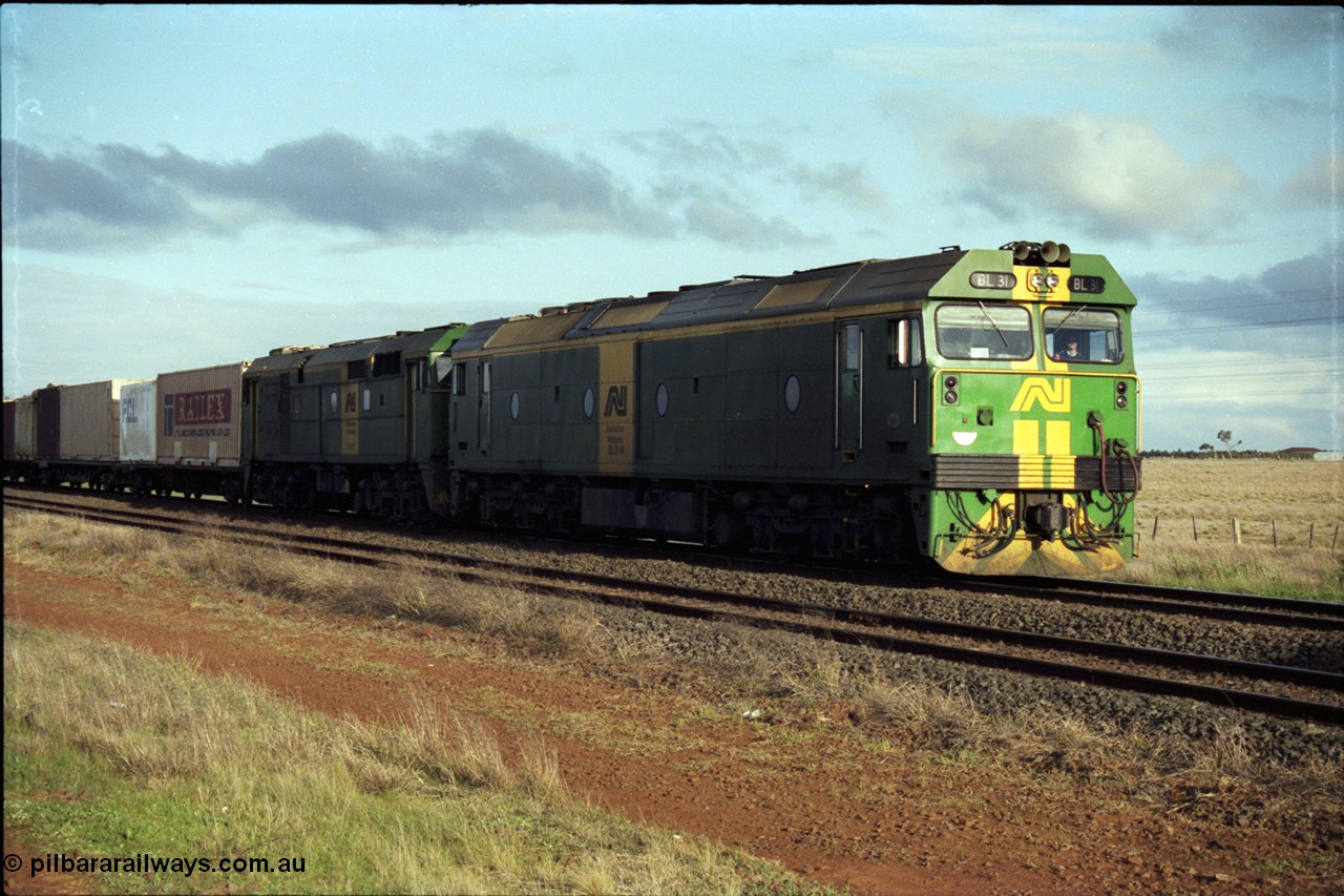 183-09
Rockbank, an Adelaide bound down broad gauge goods train behind Australian National BL class BL 31 Clyde Engineering EMD model JT26C-2SS serial 83-1015 and 700 class 705 AE Goodwin ALCo model DL500G serial G6059-3 stands on the mainline having had an up passenger train cross it.
Keywords: BL-class;BL31;Clyde-Engineering-Rosewater-SA;EMD;JT26C-2SS;83-1015;