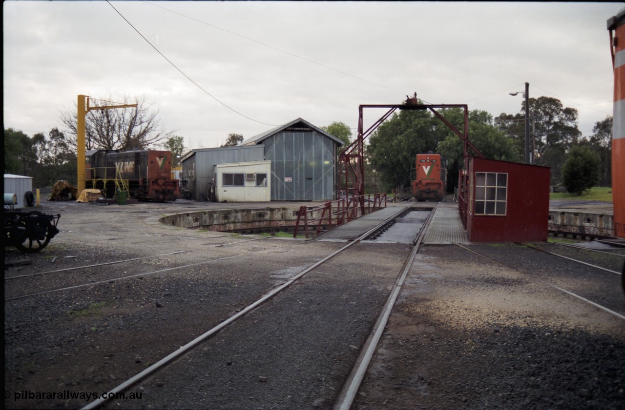 183-12
Seymour loco depot, turntable and pit, V/Line broad gauge locos, Y class an EMD Clyde Engineering G6B model under the davit crane and T class T 368 Clyde Engineering EMD model G8B serial 64-323 sits over the brake pit, loco shed, workshop and office between the locos.
