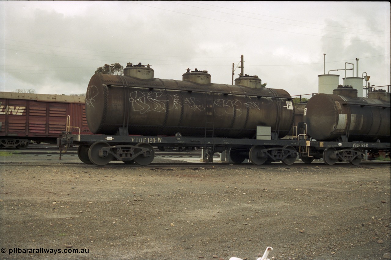 184-04
Albury station yard, broad gauge roads on the west side of the yard, through standard gauge running lines behind, V/Line VTQF type bogie fuel tank waggons VTQF 120 and VTQF 122. Both waggons built new at Newport Workshops as OT type tank waggons in May and March 1929, both to TWF in October 1961, then 120 recoded to VTQY in September 1979 and 122 to VTQY in April 1980, then in 1987/88 VTQY were recoded to VTQF.
Keywords: VTQF-type;VTQF120;VTQF122;TWF-type;Victorian-Railways-Newport-WS;OT-type;