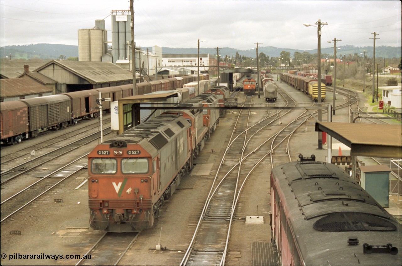 184-08
Albury station yard and loco depot fuel point overview looking north, V/Line standard gauge locos lined up awaiting the Sunday run of goods trains back to Melbourne, G class G 527 Clyde Engineering EMD model JT26C-2SS serial 88-1257, C class C 503 Clyde Engineering EMD model GT26C serial 76-826 and G class units G 520 serial 85-1233, G 525 serial 86-1238 and G 523 serial 86-1236, goods shed at left behind louvre vans, the stabled train beside the locos is SM5, elevated view.
Keywords: G-class;G527;Clyde-Engineering-Somerton-Victoria;EMD;JT26C-2SS;88-1257;C-class;C503;GT26C;76-826;G520;85-1233;G525;86-1238;G523;86-1236;