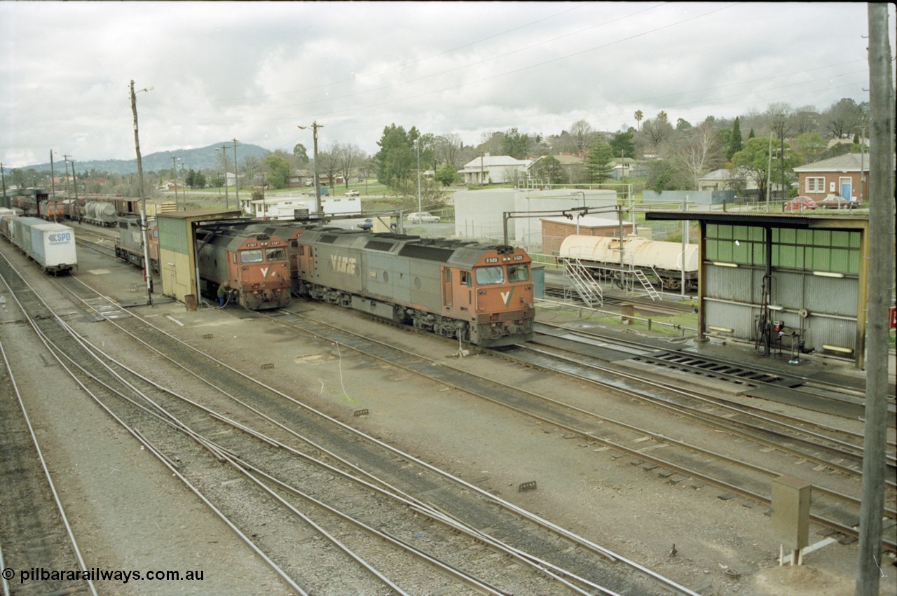 184-21
Albury station yard overview, loco depot, V/Line standard gauge G class G 527 Clyde Engineering EMD model JT26C-2SS serial 88-1257 takes on water at the fuel point with C class behind it while G class G 520 serial 85-1233 leading sister G 525 serial 86-1238 shunts past light engine, elevated view of logo depot and fuel points.
Keywords: G-class;G527;Clyde-Engineering-Somerton-Victoria;EMD;JT26C-2SS;88-1257;C-class;G520;85-1233;G525;86-1238;