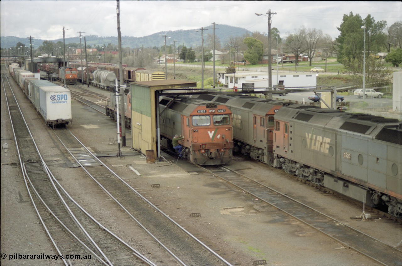 184-22
Albury station yard overview, loco depot, V/Line standard gauge G class G 527 Clyde Engineering EMD model JT26C-2SS serial 88-1257 takes on water at the fuel point with C class behind it while G class G 520 serial 85-1233 leading sister G 525 serial 86-1238 shunts past light engine, elevated view of loco depot and fuel point.
Keywords: G-class;G527;Clyde-Engineering-Somerton-Victoria;EMD;JT26C-2SS;88-1257;C-class;G520;85-1233;G525;86-1238;