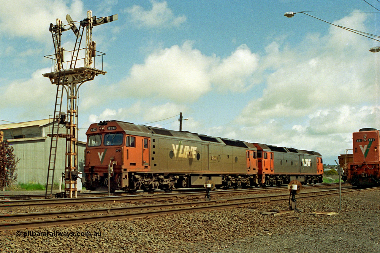 185-01
North Geelong grain arrivals, a pair of V/Line G class locomotives G 533 Clyde Engineering EMD model JT26C-2SS serial 88-1263 and G 524 serial 86-1237 run light engine to Geelong loco depot past semaphore signal post 13 having dropped a loaded grain consist on the arrival road, X class X 44 is on another loaded grain rake.
Keywords: G-class;G533;Clyde-Engineering-Somerton-Victoria;EMD;JT26C-2SS;88-1263;G524;86-1237;