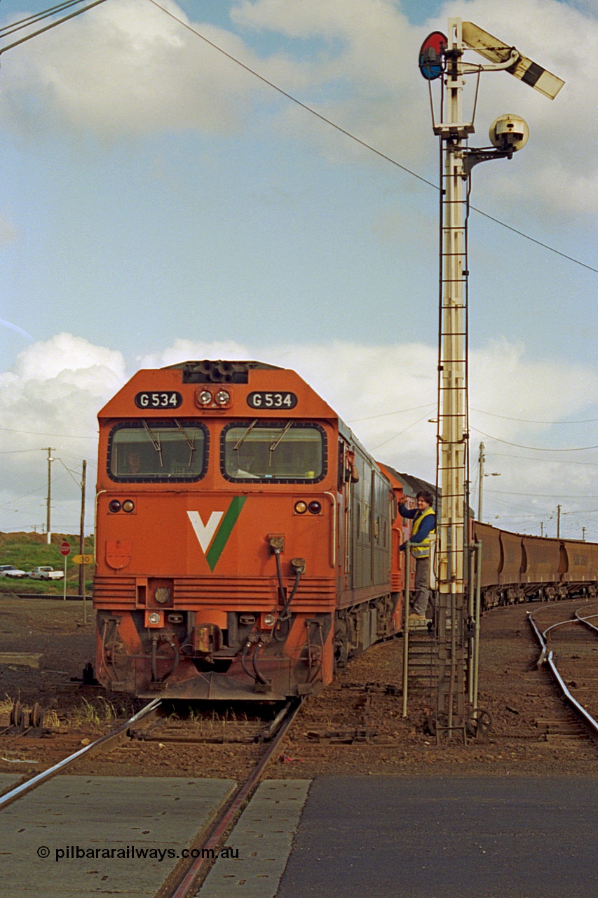 185-21
North Geelong C Box, Separation Street grade crossing, V/Line down grain train 9123 departing and having collected the electric staff for the Gheringhap section off the signaller at semaphore signal post 16 with motive power of G class G 534 Clyde Engineering EMD model JT26C-2SS serial 88-1264 leading G class leader G 511 serial 84-1239.
Keywords: G-class;G534;Clyde-Engineering-Somerton-Victoria;EMD;JT26C-2SS;88-1264;