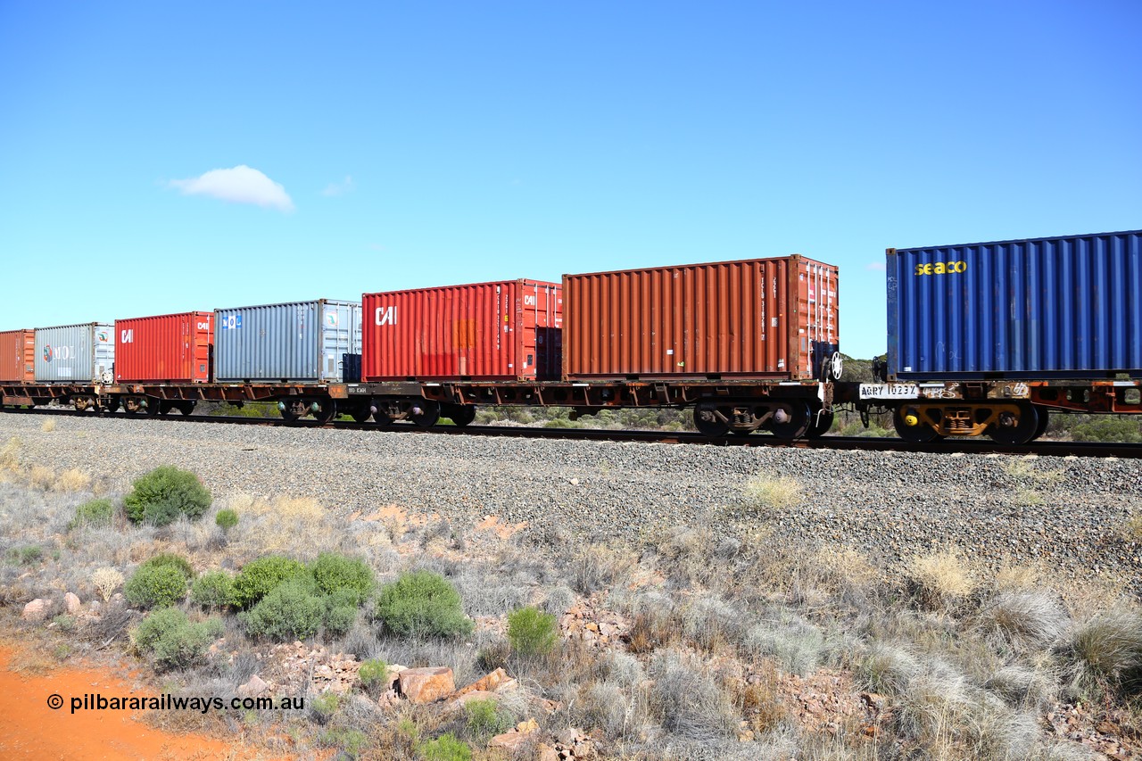 161111 2500
Binduli, Kalgoorlie Freighter train 5025, waggon AQRY 1015 platforms A and B loaded with four 20' 22G1 type boxes, TAL TCLU 318281[7], CAI CAIU 322746[9], MOL MOAU 583159[8] and CAI CAIU 328771[9]. The AQRY are a bar-coupled pair and were used for rail transport as the AFRF type on the Darwin line and are originally former ANR-CR waggons.
Keywords: AQRY-type;AQRY1015;AFRF-type;