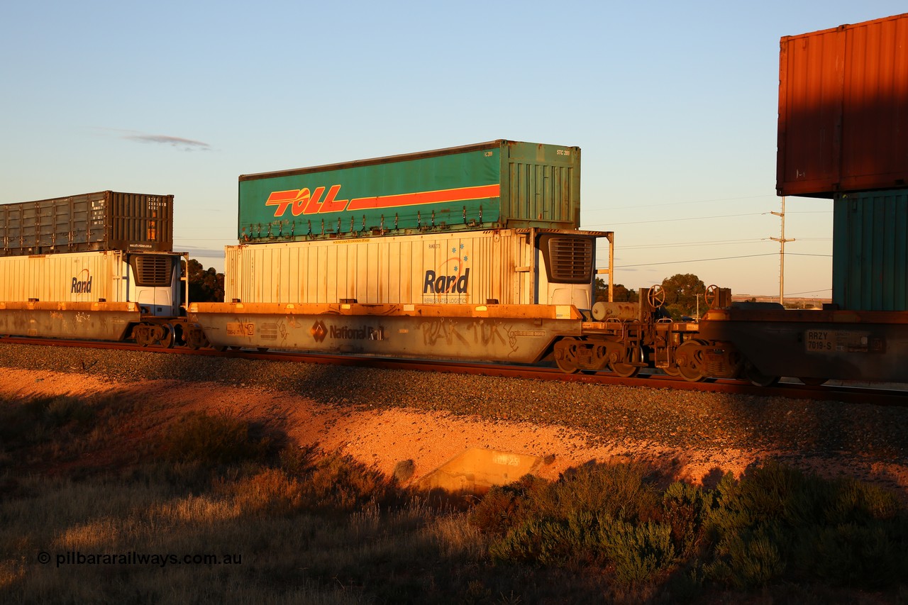 160601 10111
West Kalgoorlie, 2MP5 intermodal train, RQZY 7065 platform 5 of 5-pack well waggon set one of thirty two waggon sets built by Goninan NSW for National Rail in 1995-96, double stacked with a Toll 40' half height curtainsider 5TC 209 and Rand Refrigerated Logistics 46' 6