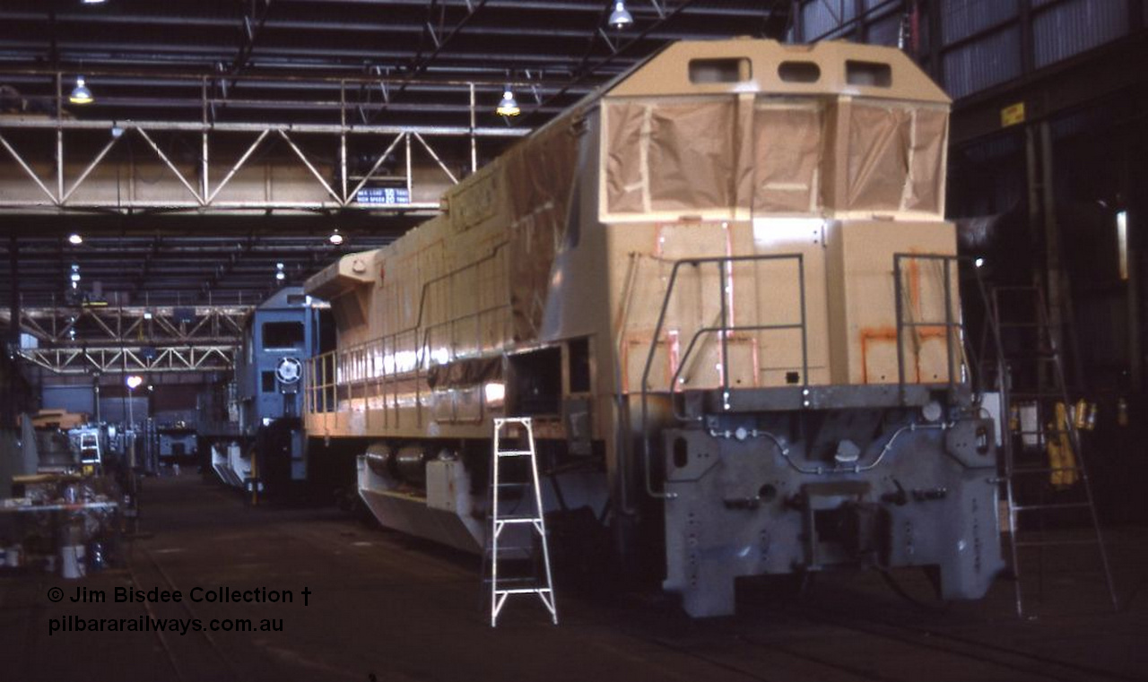 1049 001
Welshpool, Goninan Open Day 27th August, 1988. View of the assembly floor area, brand new GE CM39-8 locomotive 5631 serial 5831-10 / 88-080 under construction for Mt Newman Mining with sister unit 5632 inline behind it.
Jim Bisdee photo.
Keywords: 5631;Goninan;GE;CM39-8;5831-10/88-080;