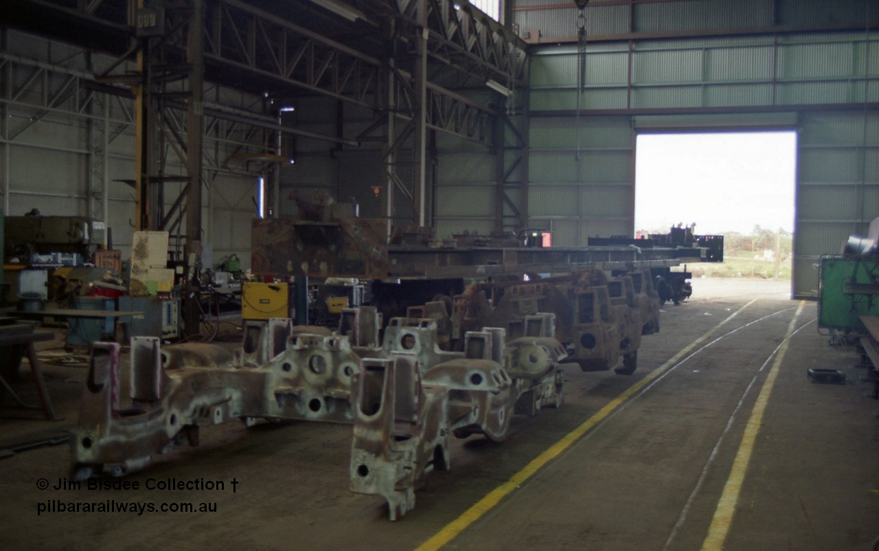22658
Bassendean, during an Open Day at the Goninan workshops, a stripped back ALCo locomotive frame under re-construction which will become a GE CM40-8M in the background and the two types of bogie which rode under the Mt Newman Mining ALCo units, in front is the ALCo Hi-Ad truck and behind is the MLW Dofasco truck. 20th July 1991.
Jim Bisdee photo.
