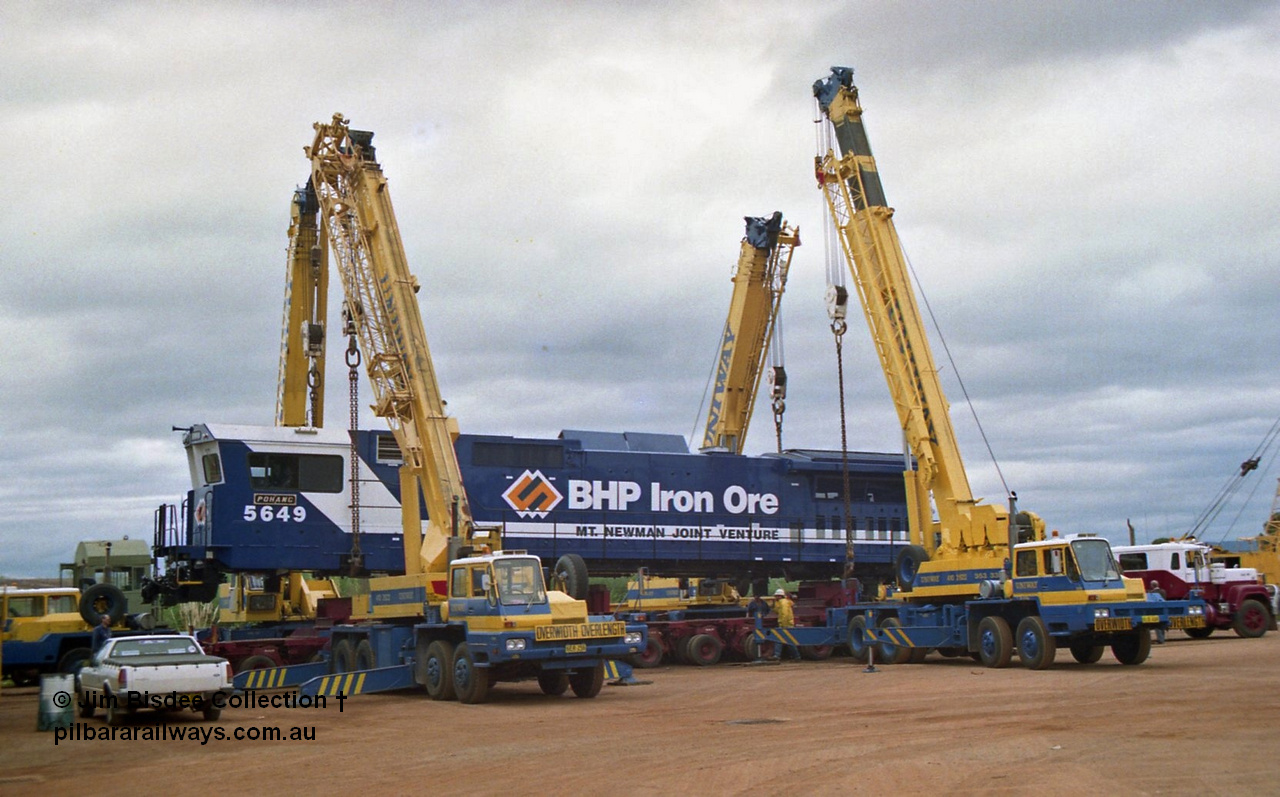 23884
Bassendean, Goninan workshops, BHP Iron Ore GE CM40-8M rebuild unit 5649 'Pohang' serial 8412-07 / 93-140 is lifted up with the Bell road transport float being prepped underneath for road haulage to Port Hedland. 5649 was rebuilt from AE Goodwin ALCo M636 unit 5473 serial G6047-5. July 1993.
Jim Bisdee photo.
Keywords: 5649;Goninan;GE;CM40-8M;8412-07/93-140;rebuild;AE-Goodwin;ALCo;M636C;5473;G6047-5;