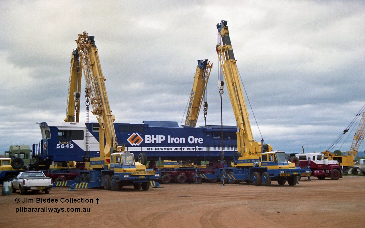 23885
Bassendean, Goninan workshops, BHP Iron Ore GE CM40-8M rebuild unit 5649 'Pohang' serial 8412-07 / 93-140 is lifted up with the Bell road transport float being prepped underneath for road haulage to Port Hedland. 5649 was rebuilt from AE Goodwin ALCo M636 unit 5473 serial G6047-5. July 1993.
Jim Bisdee photo.
Keywords: 5649;Goninan;GE;CM40-8M;8412-07/93-140;rebuild;AE-Goodwin;ALCo;M636C;5473;G6047-5;