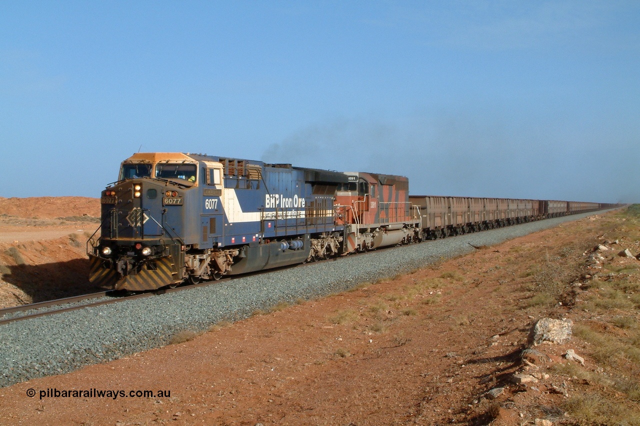 050204 080056r
Mooka, BHP GE AC6000 final unit 6077 serial 51069 with EMD SD40R 3091 serial 31496 originally Southern Pacific SD40 SP 8415 power along at the 30 km mark with an empty 200 waggon train, smoke can just been seen coming from mid train units 6071 and 3083 4th February 2005.
Keywords: 6077;GE;AC6000;51069;
