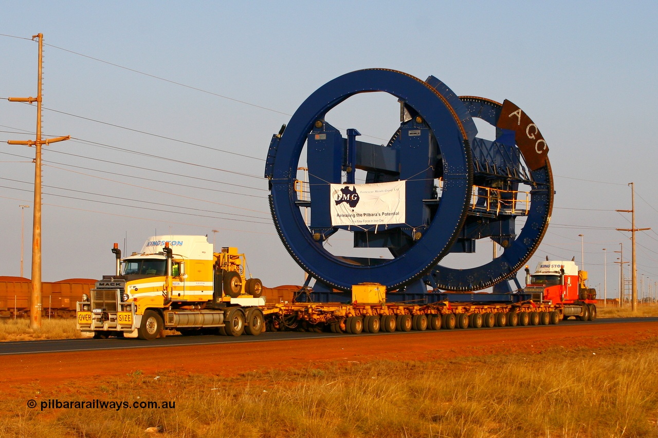 070923 1044r
Port Hedland, Wilson Street, two Kingston Mack prime movers power the 256 wheel float with the second Metso built rotary dumper cell for FMG. Seen here approaching the Redbank Bridge. Of note is these cells for FMG will clamp the top of the ore waggon, similar to the Pilbara Iron dumpers, while the BHP cells clamp down on side pockets in the waggons. Sunday 23rd September 2007.
