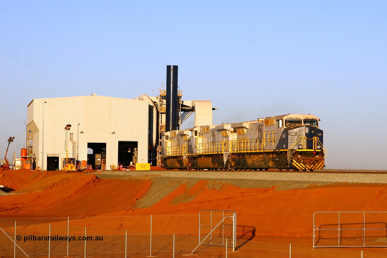 080525 2409r
Boodarie, FMG's car dumper sees General Electric built Dash 9-44CW combo of 009 serial 58156, 008 serial 58155 and 005 serial 58182 departing the dumper having spotted the loaded rake and make their way around to the 4 km area to stable. The locos are at the 0.0 km and the loaded rake can be seen in the background. 25th May 2008.
Keywords: FMG-009;GE;Dash-9-44CW;58186