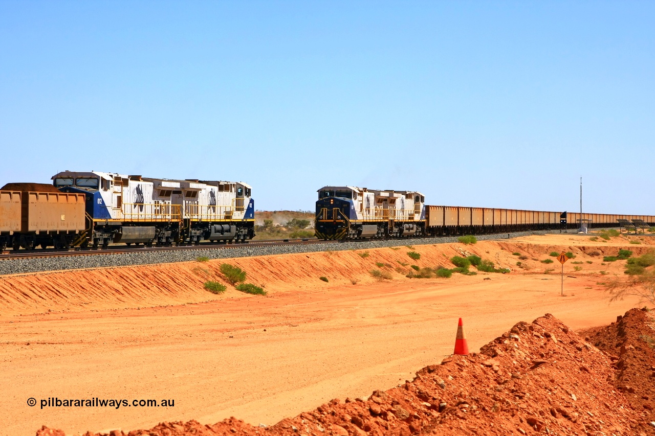 090814 2109r
Hunter Siding, the empty train takes the passing track under the power of two FMG General Electric built Dash 9-44CW units 011 serial 58188 and 010 serial 58187, while another pair of identical units 002 serial 58179 and 012 serial 58189 hold the mainline and will wait for a new PA to continue towards the port. The dust between the two trains is from the BHP access road. 14th August 2009.
Keywords: FMG-011;GE;Dash-9-44CW;58188;