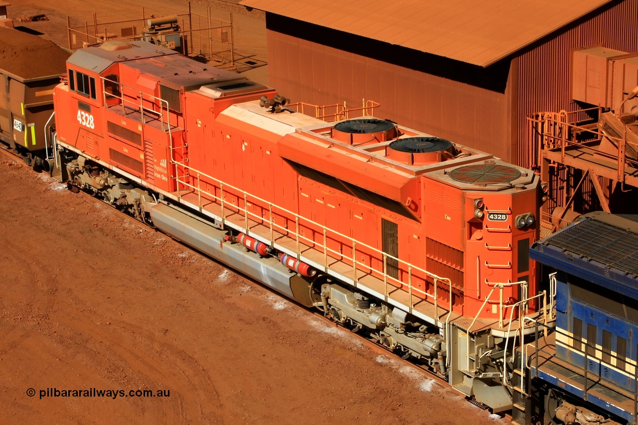 100508 8250
Nelson Point, BHP Billiton 'Pumpkin' unit 4328 was built by Electro-Motive as an EMD model SD70ACe for the BNSF railroad in the USA with serial 20066862-057 but was sold to BHP while under construction as one of ten similar units to be diverted to BHP in an all over BNSF base orange earning them the nickname of 'pumpkins' after the BNSF livery. They were standard US domestic units and required substantial modifications to be afforded lead unit status for BHP. This elevated view shows the tropical roof, non-slip paint on the hood, marker lights and modified sand fillers, rear end plough, fire suppression tanks and dual handrail. 8th May 2010.
Keywords: 4328;Electro-Motive-London-Ontario;EMD;SD70ACe;20066862-057;BNSF-9186